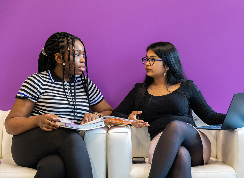 Two women sitting down talking